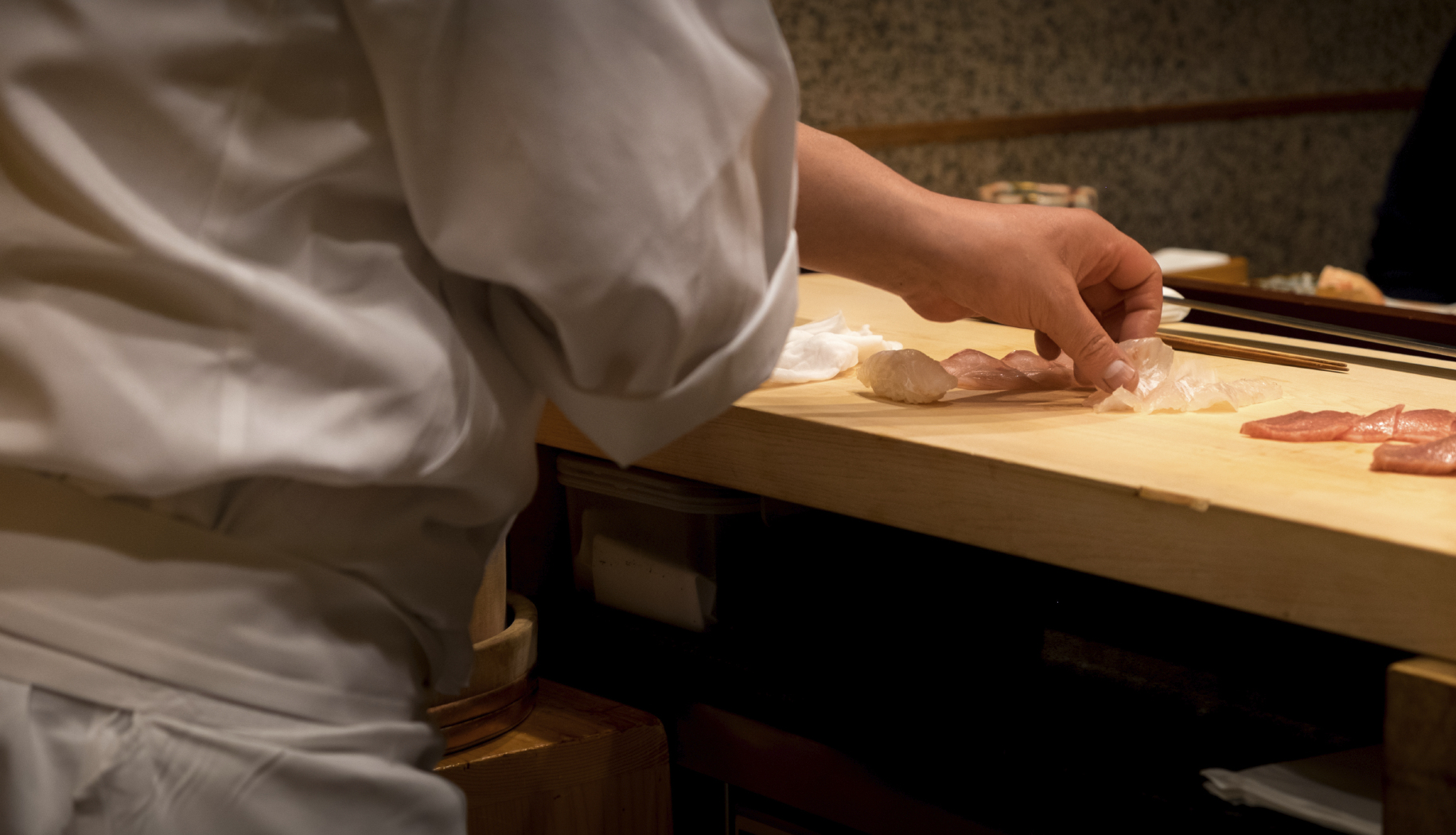 Japanese chef slicing fresh raw fish for sushi