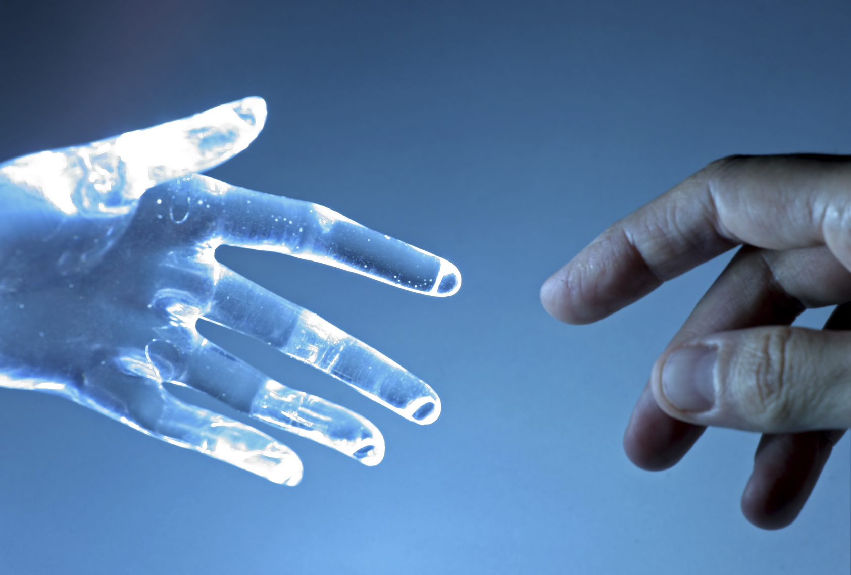 Human hand touch an atrifical glass hand