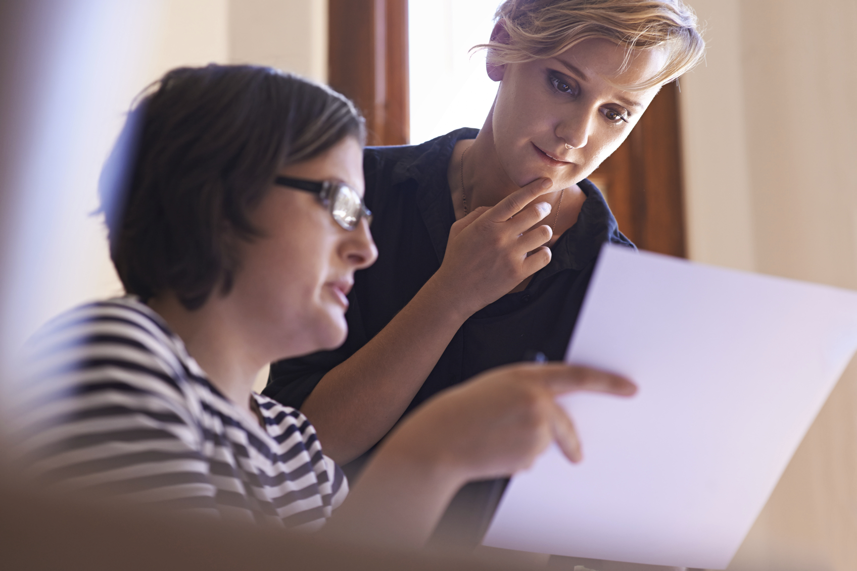 A cropped shot of two women working together in a home office