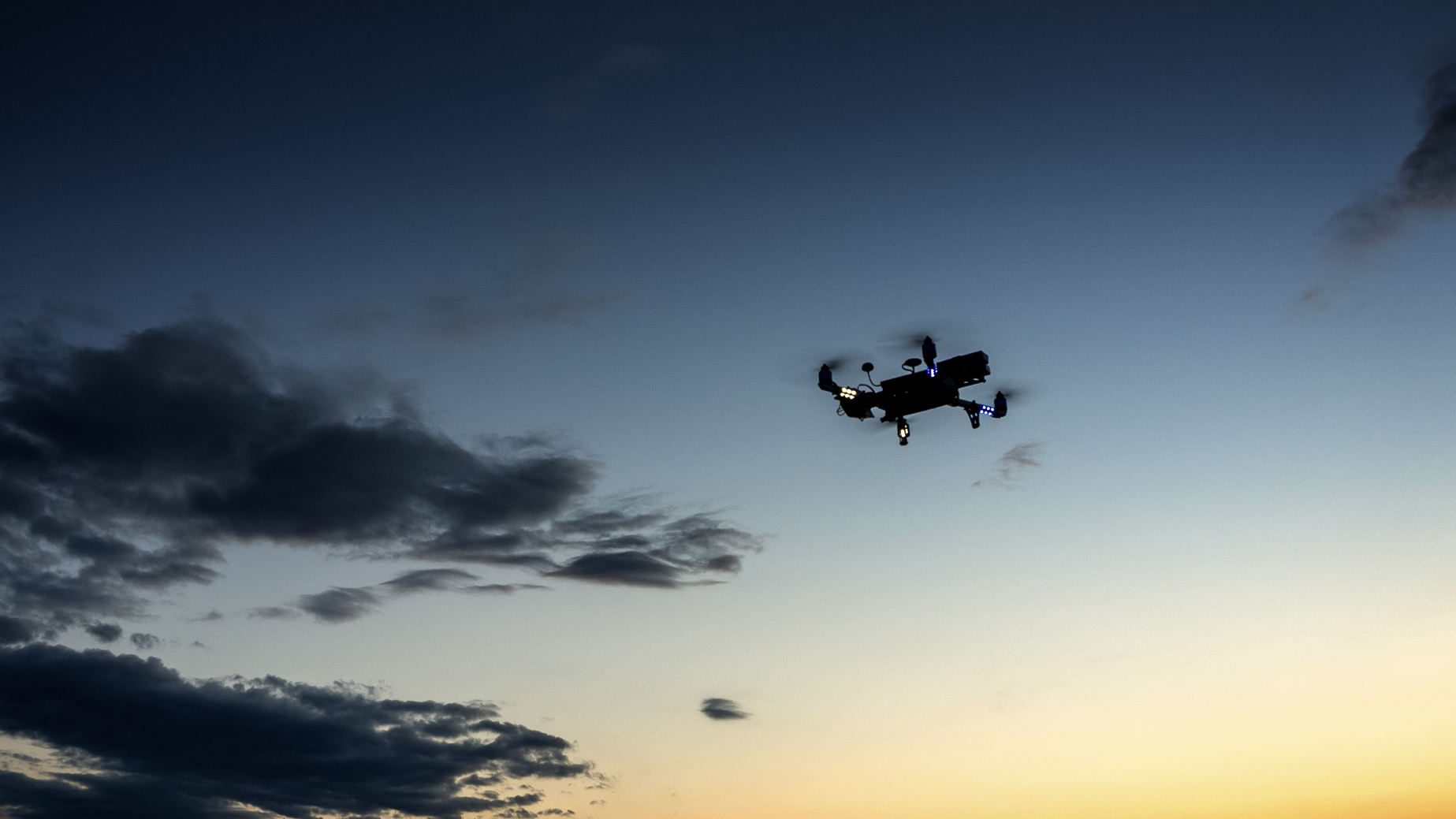 UAV or Quadcopter so called Drone against evening sky. Multirotor.